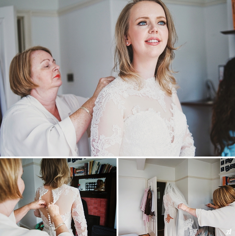 Bride getting her dress on with help from Mother of the Bride