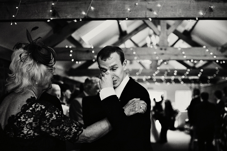 A black and white portrait of an emotional groom at Heaton House Farm