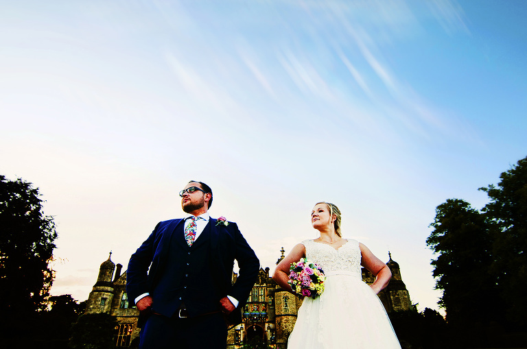 Colourful portrait of a bride and groom posing as superheroes at hengrave hall.