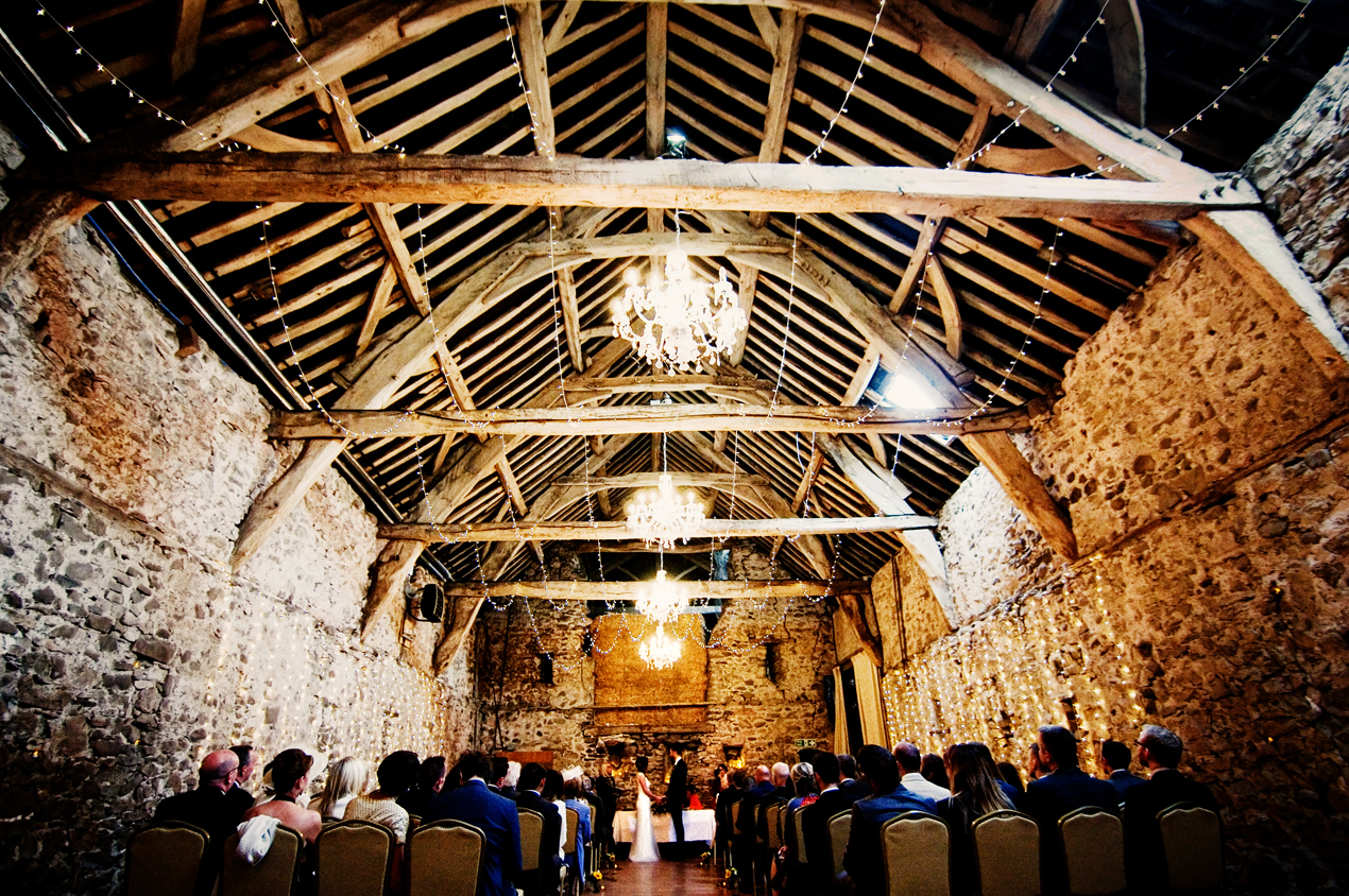 Park House Barn wedding photography of a beautifully candle-lit ceremony within the rustic venue.