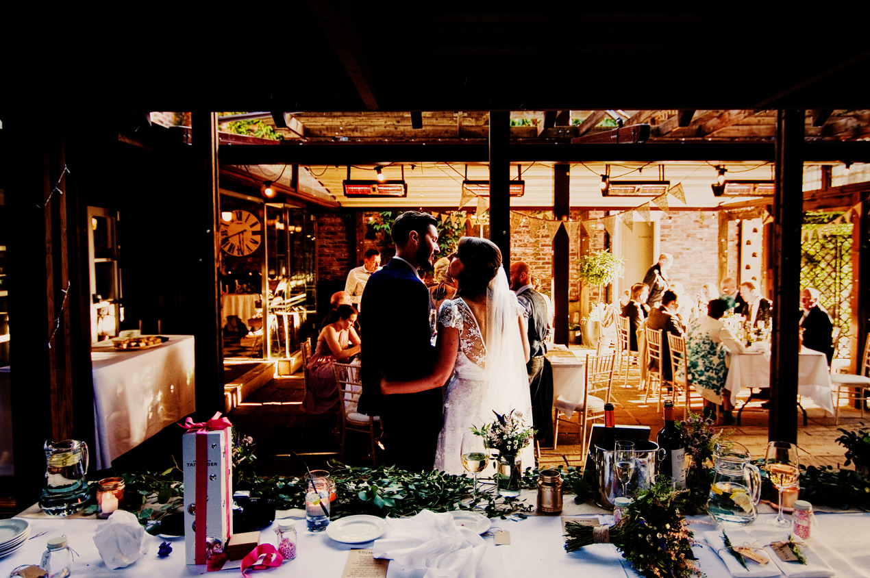 Eleven Didsbury Park Wedding photography of a just married couple looking at each other in the beautiful garden and outdoor eating area.