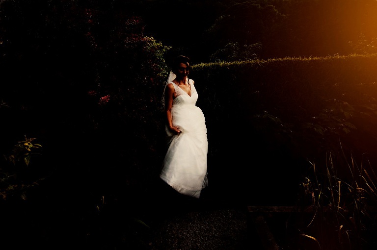 Bride walking through gardens at the inn at whitewell on a summer's evening