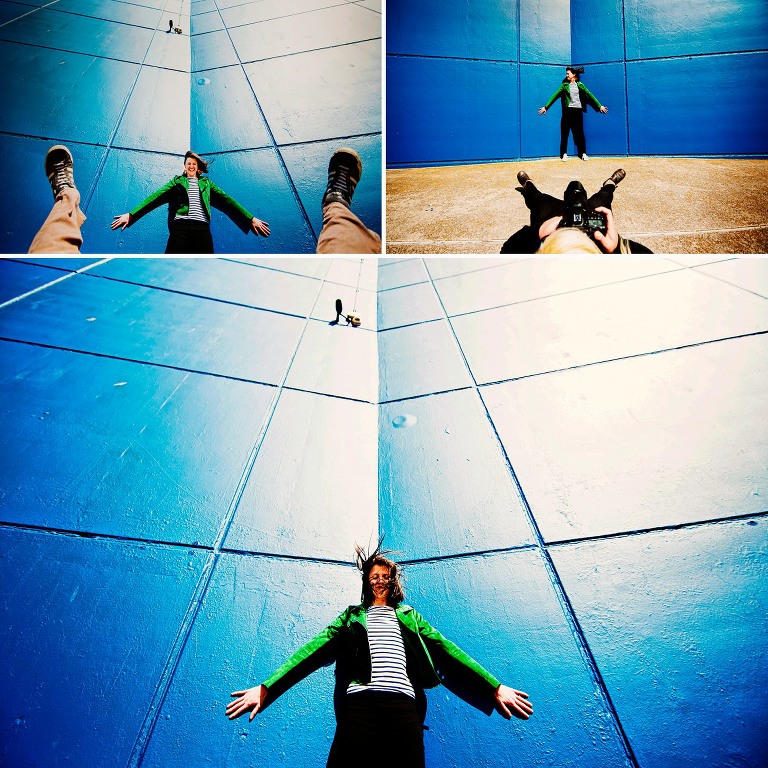 Zoe from About Today Photography next to a bright blue wall wearing a funky biker jacket, taken by ZT Photography.