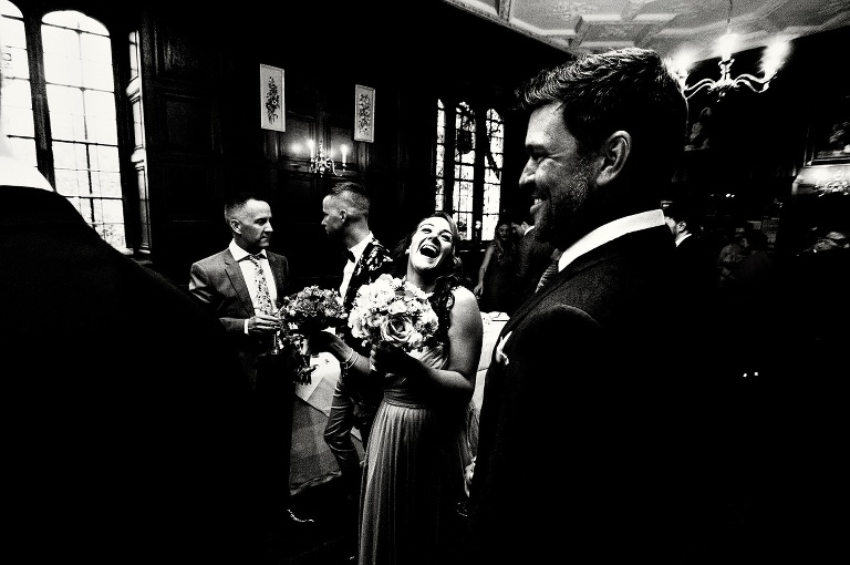 Bridesmaid laughing with boyfriend at Hengrave Hall.