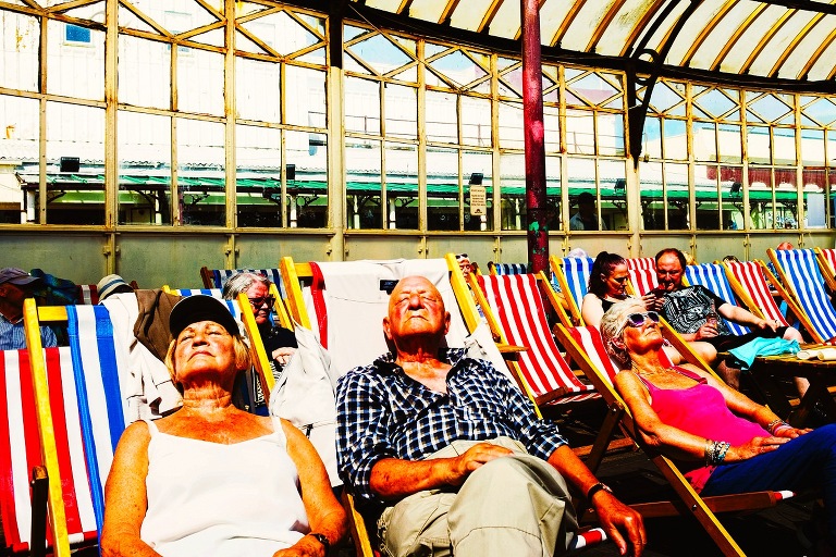 holdaymakers sunbathing on deckchairs, north pier, blackpool.