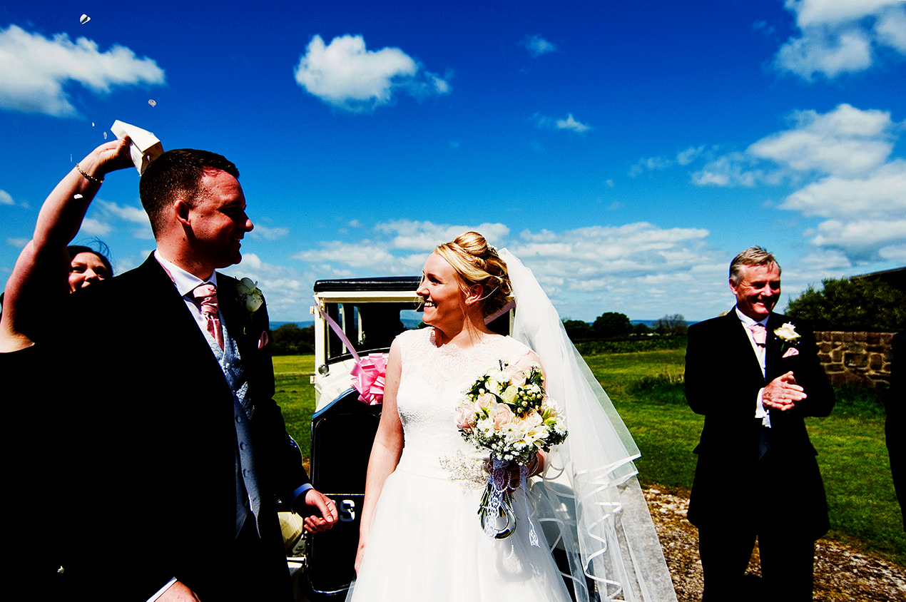 Fun documentary weeding photo of a bride and groom with blue skies and fluffy clouds at beeston manor wedding venue near Preston.