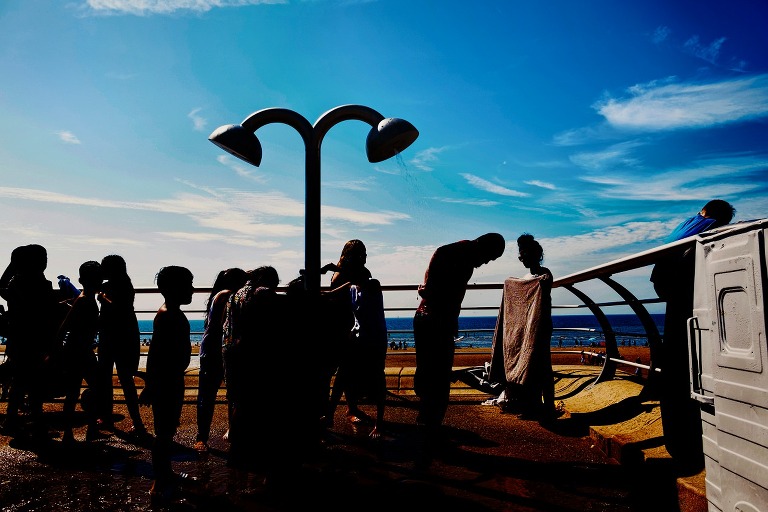 Silhouettes of children washing under sprinklers in Blackpool.