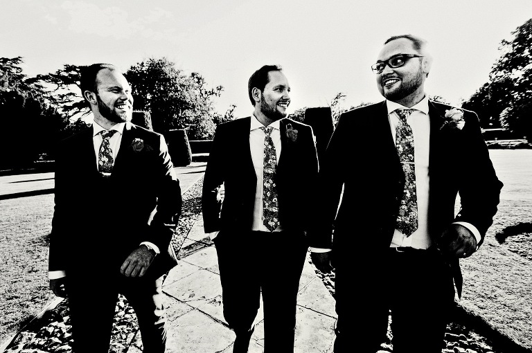 Groom and best man walking in the grounds of Hengrave Hall.