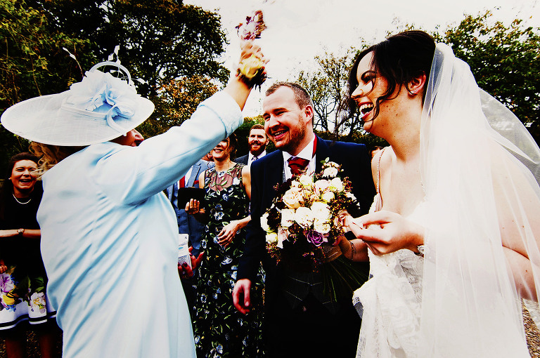 Mother of groom throwing confetti at holdsworth house in yorkshire.
