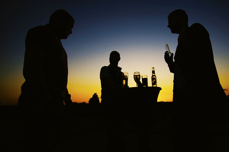 Sunset at a beeston manor wedding with guests drinking lager.