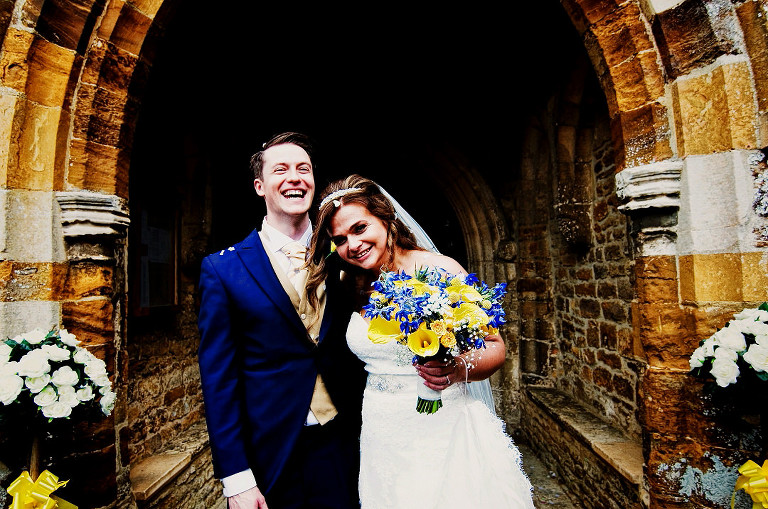 Bride and groom in confetti shot outside a church in Walgrave Northamptonshire