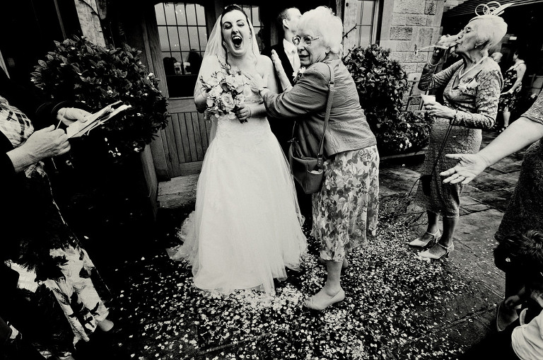 Bride and grandmother laughing after confetti throw at Heaton House Farm wedding